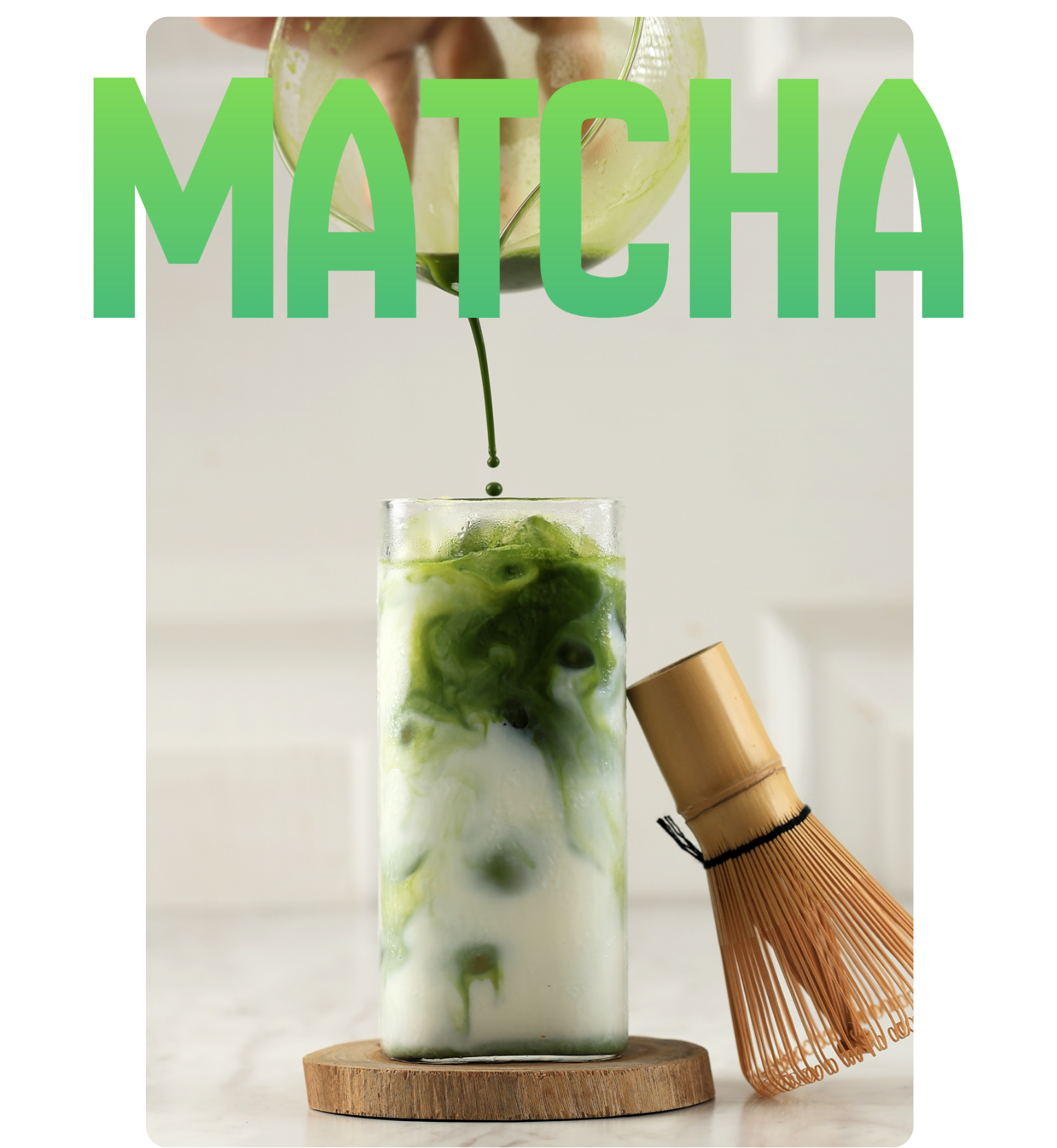 Matcha green tea being poured into a glass with a whisk on a white background